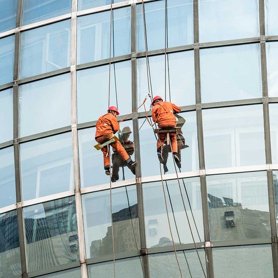 Fensterputzer an der Glasfassade eines Hochhauses