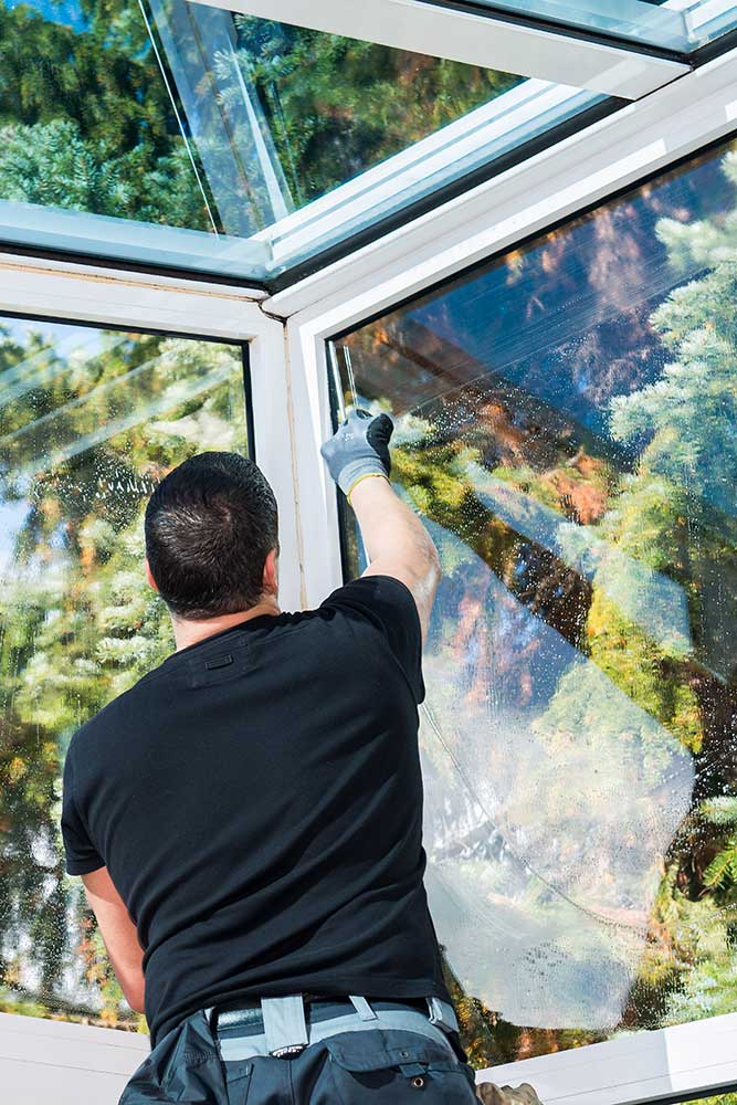 gebäudereiniger arbeitet im wintergarten