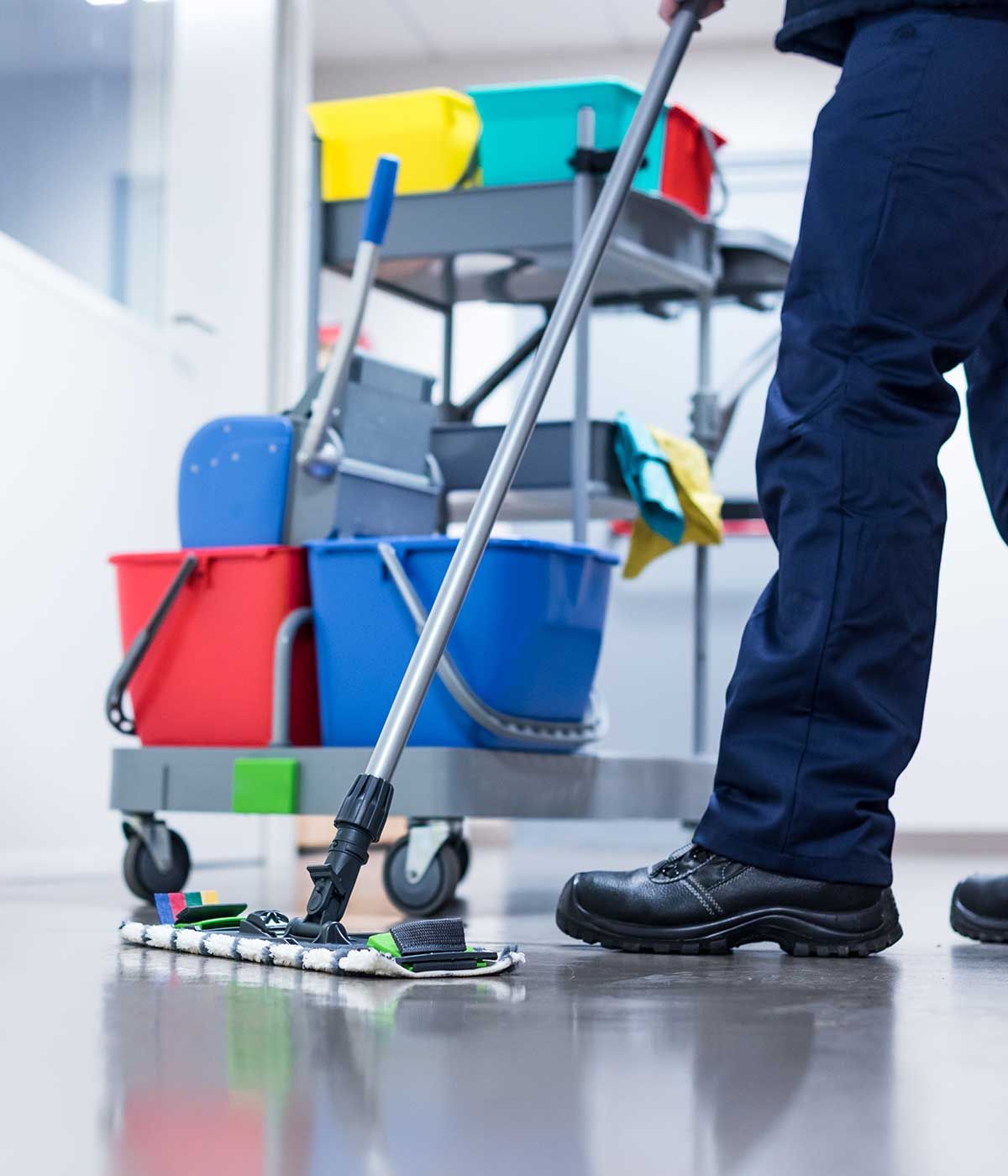 Hausmeister wischt den Boden im Büro mit einem Wagen