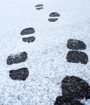 Winterfußtritte im Schnee auf dem Boden